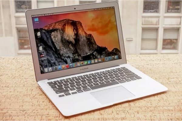 MacBook air de color gris y con la pantalla encendida