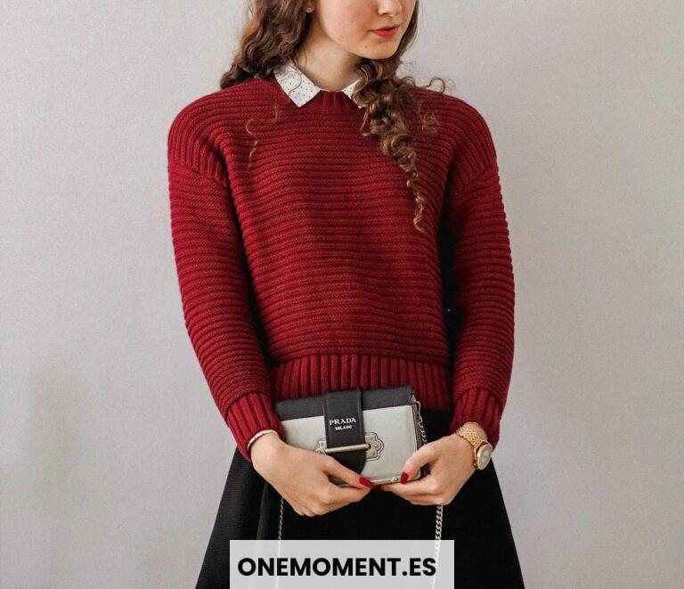 woman in red sweater holding white box