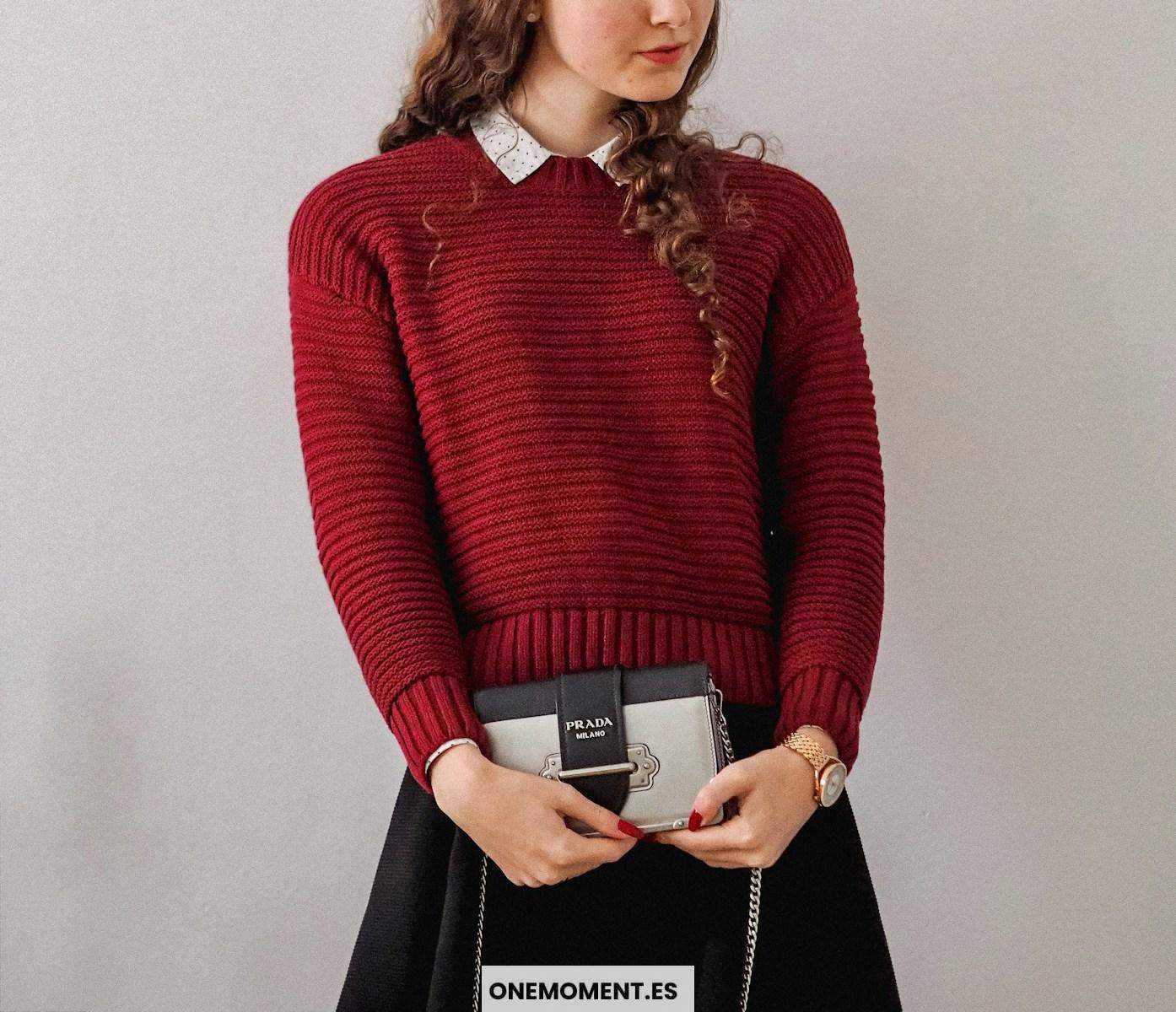 woman in red sweater holding white box