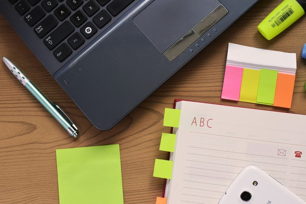 Escritorio con portátil, cuaderno y bolígrafo preparados para escribir